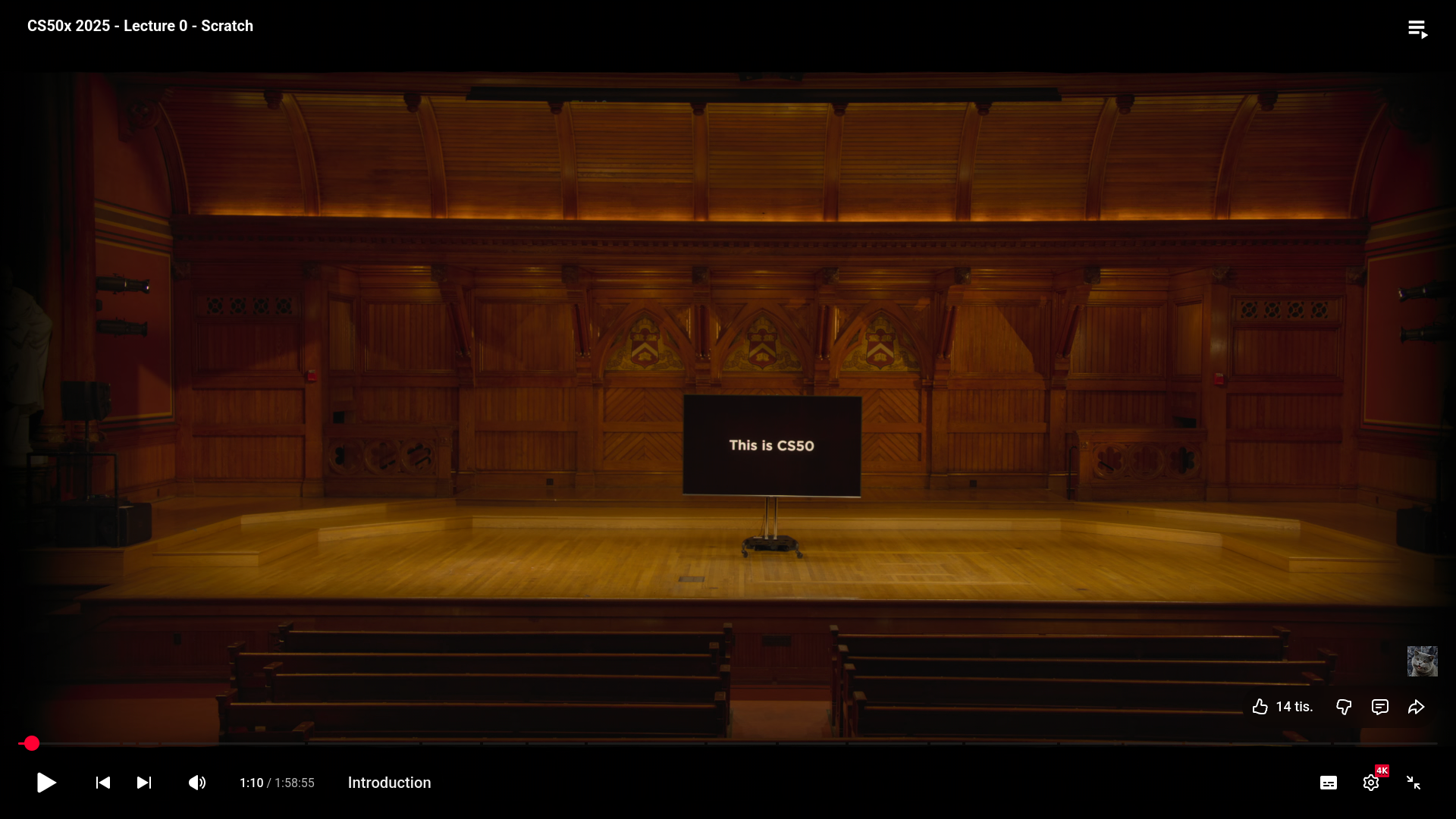 Úvodná prednáška CS50x v Sanders Theatre na Harvarde s nápisom „This is CS50“ na obrazovke.